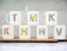 six coffee mugs with the letters k, h, and w painted on them