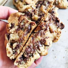 chocolate chip cookies are stacked on top of each other in the palm of someone's hand