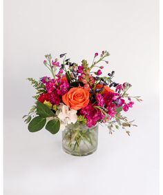 a vase filled with lots of colorful flowers