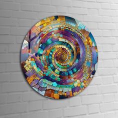 a circular mosaic artwork on a white brick wall in the shape of a colorful spiral