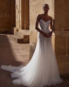 a woman in a wedding dress posing for the camera