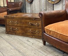 two brown leather chairs and an old trunk