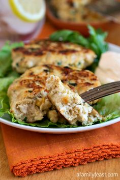 a white plate topped with chicken patties and lettuce