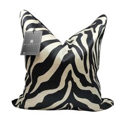 a black and white zebra print pillow with a tag hanging from it's side