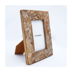 a wooden frame with an intricate design on the front and sides, holds a 4x6 inch photo