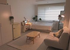 a living room filled with furniture and a white couch next to a small table on top of a rug