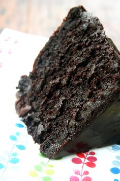 a piece of chocolate cake sitting on top of a napkin