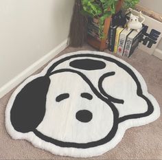 a rug with a dog's head on it in front of a potted plant