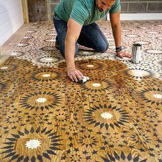 a man is working on an intricately designed floor