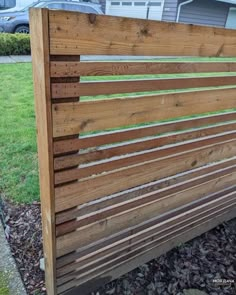 a wooden slatted fence in front of a house