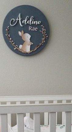 a baby's crib with a name plate on the wall