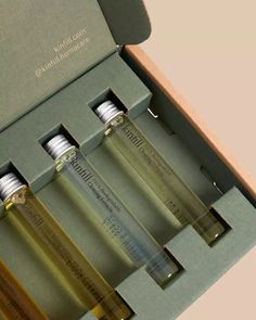 three small bottles in a green box with silver caps