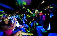 a group of people on a bus with neon lights