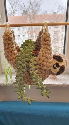 a stuffed slotty hanging from a clothes line with succulents attached to it