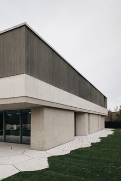 an empty building sitting on top of a grass covered field next to a parking lot