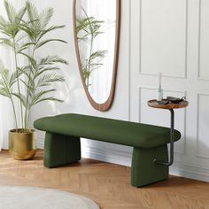 a green bench sitting in front of a mirror