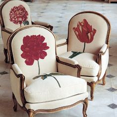 two chairs with flowers painted on them in a room