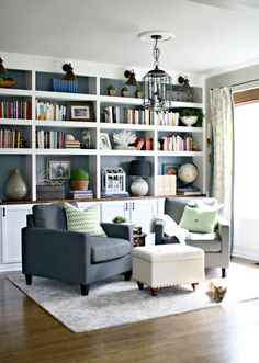 a living room filled with lots of furniture and bookshelves on top of it