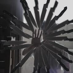 a man is holding his hands in the middle of a large circular arrangement of knives