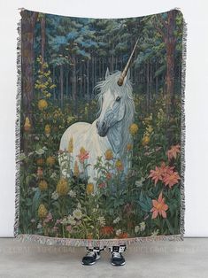 a tapestry with a unicorn and flowers in the background is hanging up on a wall