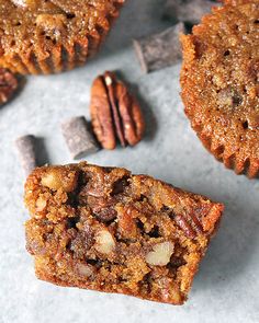 two pieces of pecan pie sitting on top of a table next to some pecans