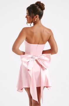 The Freja mini dress is party perfection. Crafted in luxurious stretch satin, this beautiful design is strapless with a corseted bodice and flirty, flouncy skirt. A dramatic bow to the back finishes the look. 



Colour: Blush.

Luxury stretch satin.

Oversized bow to back.

Strapless.

Corset body.

Zip fastening to reverse.

Mini length.

Model is an XS and is wearing an XS.

 Size: XS, S, M, L, XL, XXL Homecoming Dresses Corset, Cute Homecoming Dresses, Strapless Corset, Maxi Dress Sale, Sparkle Dress, Blush Dresses, Grad Dresses, Dresses By Length, Hoco Dresses