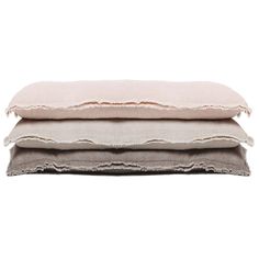 three pillows stacked on top of each other, one with fraying edges and the other in