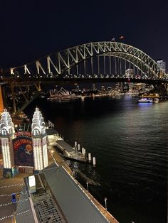 the sydney harbour bridge is lit up at night with lights on it's sides