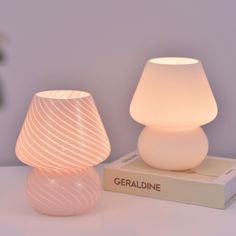 a white lamp sitting on top of a box next to a light bulb in the shape of a vase