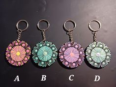 four key chains with different designs on them and the letters abc, c, d