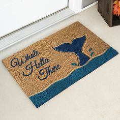 a door mat with the words whale hello there on it next to an orange pumpkin