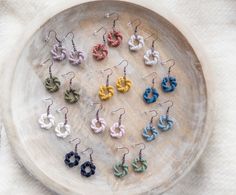 the small earrings are made out of yarn and have tiny rings on them, all in different colors