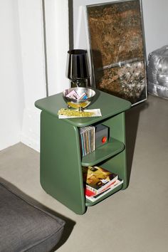 a small green end table with magazines on it