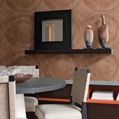 a dining room table with two vases on top of it and a mirror in the background