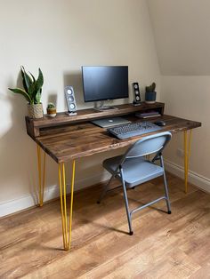 a wooden desk with a computer on top of it and a chair next to it