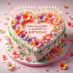 a heart shaped birthday cake with flowers and candles