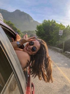 a woman leaning out the window of a car