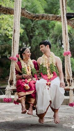 a man and woman sitting on a swing