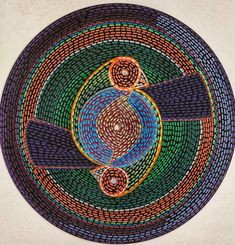 a circular design made out of various colored stones on a white surface with an orange and blue circle in the center