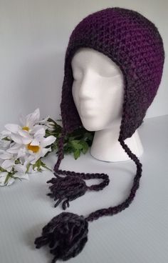 a crocheted hat and flower on a mannequin head