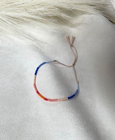 a string bracelet on top of a white sheet