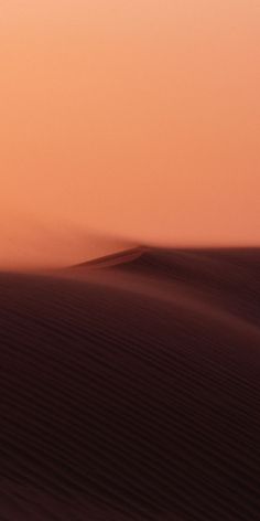 a person walking in the desert at sunset