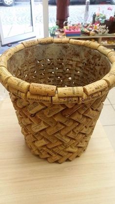 a basket made out of wine corks on a wooden table in front of a store window