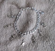 If you are checking out my feedback and see that I have sold something that you would like please just drop me a line.  I can almost certainly make you another one. Thanks. THIS ITEM Really sweet silver coloured charm bracelet made from metal (NOT sterling silver). The chain is lightweight aluminium and the charms are plated to look like silver. 7 charms in the shape of a teddy bear holding a flower and 1 heart-shaped charm which says 'made with love'. Large lobster claw clasp for security. Each Handmade Silver Charm Bracelet For Birthday Gift, Silver Charm Bracelet For Best Friend Gift, Silver Charm Bracelet For Best Friend, Personalized Silver Charm Bracelet For Gift Making, Silver Bracelet Jewelry For Gift Making, Silver Charm Bracelet With Lobster Clasp For Personalized Gift, Handmade Silver Charm Bracelet For Mother's Day, Charmed Show, Cute Teddy Bear