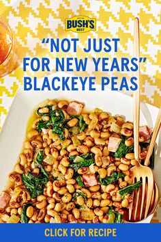 a white plate topped with beans and spinach next to a glass of orange juice