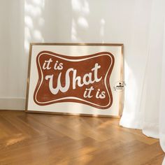 a brown and white sign sitting on top of a wooden floor