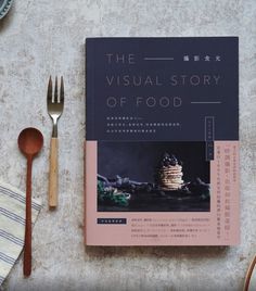 the visual story of food book next to utensils