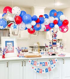 balloons and streamers decorate the kitchen for an american patriotic party with red, white, and blue decorations