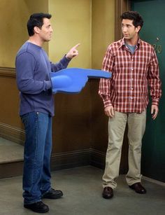 two men standing next to each other in front of a door with a frisbee