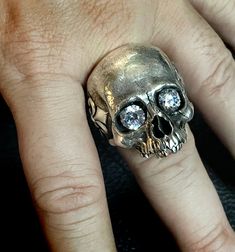 RING PROFILE: 🔱Our Mortis Fleur de Lis silver skull ring is certainly one of the most anatomically accurate and detailed skull rings on the market. We have meticulously created a statement skull ring full of character and personality. Its old and subtly sad-looking expression represents the experience and burden of a human life. 🔱To make this skull ring an even more extraordinary piece we have attached a Fleur-de-Lis on each side of the temple and the word MORTIS wrapped around the ring band t Alexander Mcqueen Skull Ring, Sterling Silver Skull Ring In White Gold, Hand Cast Sterling Silver Skull Ring, Octopus Jewelry, Skull Rings, Exotic Jewelry, Silver Skull Ring, Tarnish Remover, Biker Rings